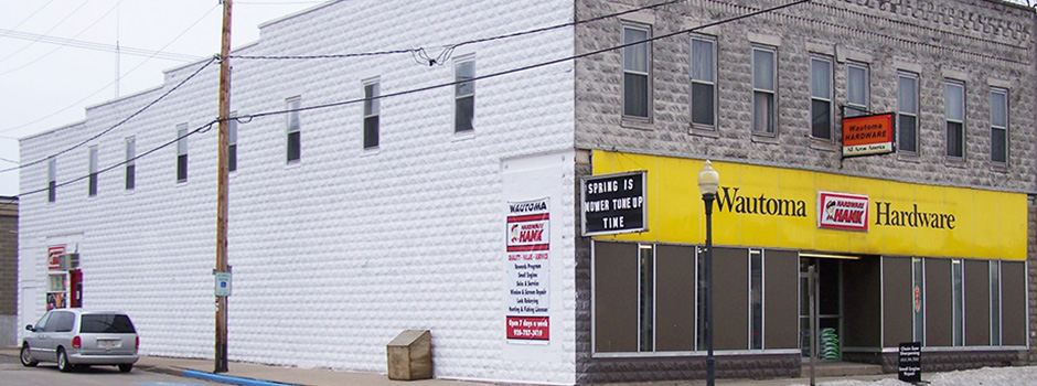 Wautoma Hardware storefront, brick with yellow sign