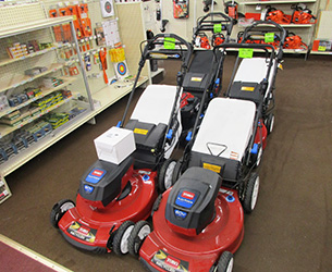 Two red Toro push mowers
